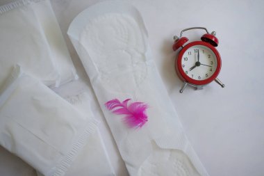 Renkli arka planda hijyenik ped, çalar saat.