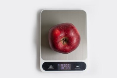 Kitchen scales, apple on a light background
