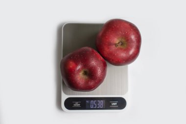 Kitchen scales, apple on a light background