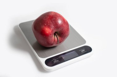 Kitchen scales, apple on a light background