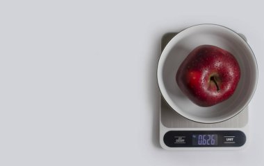 Kitchen scales, apple on a light background