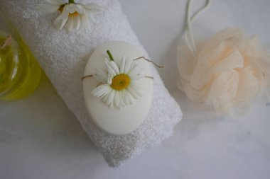 Cosmetic soap, chamomile flower on a light background