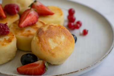 Tabağında böğürtlen olan peynirli kekler