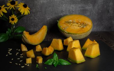 Masada taze kavun dilimleri ve parçalar var.