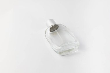 Elegant empty perfume bottle lying on white background. Perfect for cosmetic branding, minimalist flat lay, product display, or advertising mockups. Isolated on white. 