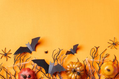 Kara hediye kutuları, yarasalar, örümcekler ve turuncu arkaplandaki ağlarla Cadılar Bayramı arkaplanı..