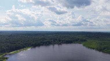 Bereketli Amazon yağmur ormanları sakin nehirle birleşiyor, güneş ışığı bulutlu gökyüzünü delip geçiyor, Ekvador 'daki el değmemiş vahşi doğayı vurguluyor..