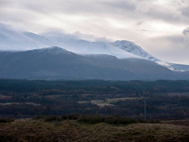 Nevis Sıradağları, Spean Köprüsü 'nün kuzeyindeki Komando Anıtı' na bakıyor. Aonach Mor 'un kayak pistleri, Carn Mor Dearg' ın dalgalanması ve Ben Nevis 'in bulutların altındaki zirvesi..