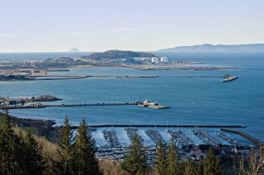 Haylie Brae bakış açısı, işletim sistemi haritası hakemi NS 214 585. Largs, Ayrshire, İskoçya. 12 Mart 2025. Largs marinası, Fairlie ve Hunterston Elektrik Santrali üzerinde güneşli bir gündüz manzarası. Ailsa Craig ufukta görünüyor.. 