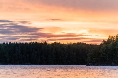 Gün batımında ağaçlarla göl