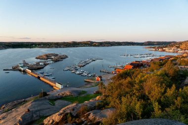 Akşam güneşinde Norveç adasının köyünün körfezinden manzara