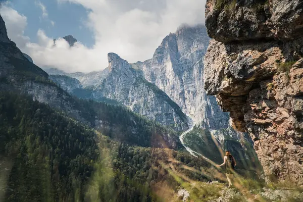 Sırt çantalı genç adam yazın dağların tadını çıkarıyor..
