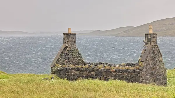 Rüzgârlı bir sahil tepesinde terk edilmiş bir taş kulübe dalgalı denizlere ve uzak tepelere bakan, yalnızlığı ve engebeli mirası çağrıştıran. Bu atmosferik manzara fotoğrafı seyahat, tarih ve doğa kullanımı için idealdir. Harris Adası İskoçya