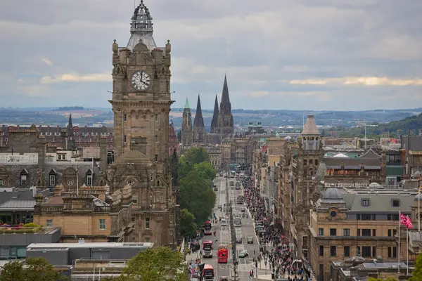 Edinburgh şehir merkezi, mimariyi ve canlı sokakları yakalıyor. Tarihi binalar, saat kulesi ve hareketli kalabalıklar.