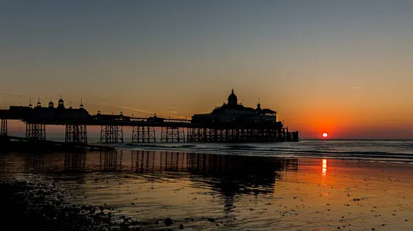 Öndeki Brighton İskelesi siluetinin üzerinde çarpıcı bir günbatımı dramatik ve resimsel bir sahne yaratıyor..