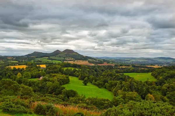 Scotts View, bulutlu bir gökyüzü altında yuvarlanan tepelerin, yeşil tarlaların, ormanların ve uzak dağların manzaralı manzarası, seyahat, turizm veya çevre temaları için mükemmel..