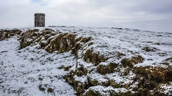 Solomons Tapınağı, bir taş kule karla kaplı bir tepenin üstünde, bulutlu gökyüzü ile kışın manzarasına dramatik bir zemin ekliyor..