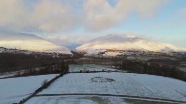 Doğal elementlerle eşsiz dairesel bir oluşumun havadan görünüşü. Desen, karmaşık detaylarla dokulu, beyaz bir yüzeyle çevrili. Kışın Casterigg Taş Çemberi 'nin havadan çekilmiş bir fotoğrafı..