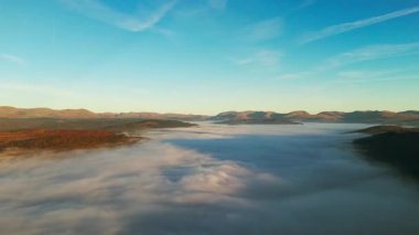 Yuvarlanan tepeler ve vadilerden oluşan güzel bir manzara, berrak mavi bir gökyüzünün altında kalın bir sis tabakasıyla örtülmüş. İnsansız hava aracı görüntüleri, Gummer 's How in the Lake District England' da güneşin doğuşunu kaydediyor..