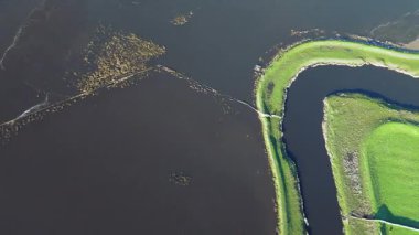 Havadan bakıldığında, yemyeşil bankalarla çevrili, huzur ve sükuneti çağrıştıran, sakin bir manzaranın içinden akan kıvrımlı bir nehir görülüyor..