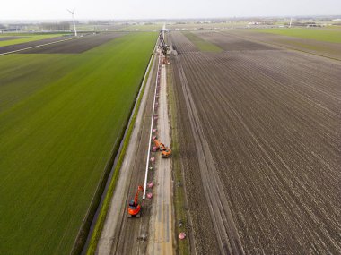 Seralara karbondioksit gazı sağlayan bir boru döşemek. Ele geçirilen ve geri dönüştürülen bu gaz aslında endüstriyel süreçler tarafından üretildi ve küresel emisyonların azaltılmasıyla sonuçlandı.
