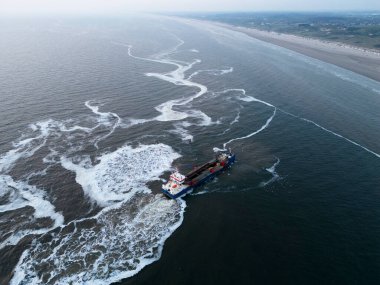 Kıyıdan uzak bir rüzgar parkından Hollanda 'nın Wijk aan Zee kentindeki bir karasal güç merkezine deniz kenarı kurulumu için hazırlık yapan bir süzgeç..