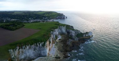 Aerial view of the famous white limestone cliffs near Etretat during sunset, France clipart