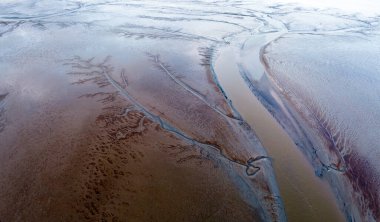 Eemsdelta, Groningen, Hollanda 'nın gelgit çamur düzlüklerinin ve kanallarının hava görüntüsü