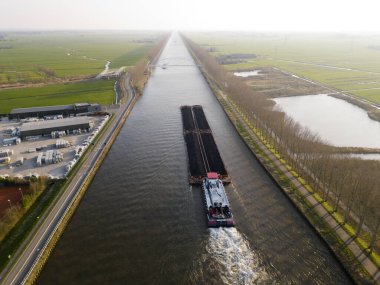 Hollanda 'daki Amsterdamrhine Kanalı' nda bir çekici ve kömür dolu bir panton görüntüsü.