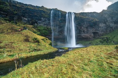 İzlanda 'daki Seljalandsfoss şelalesinin uzun pozlama fotoğrafı ipeksi, pürüzsüz bir su etkisi yaratıyor. Önden çekilen bu resim, bu ünlü çağlayanın zarafetini ve güzelliğini vurguluyor..
