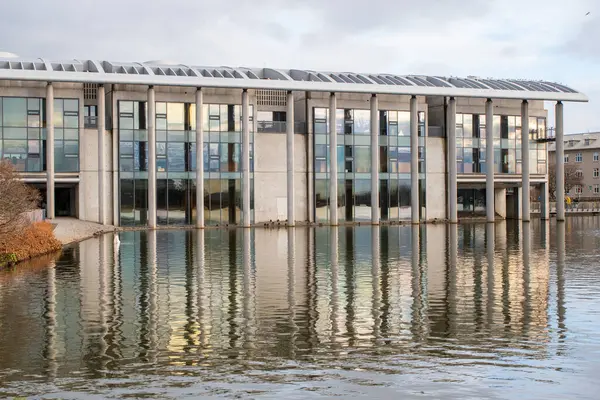 Reykjavk 'taki modern ziyaretçi merkezi yakındaki gölün sakin sularına yansıdı. Temiz mimari, doğal ortamla çok güzel zıtlaşıyor..