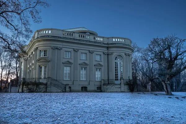Braunschweig, Almanya 'da soğuk zemin ve çıplak ağaçlarla aydınlatılmış zarif barok sarayı. Akşamları romantik bir mimari sahne..