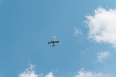 Aşağıdan çekilen uçaklar mavi gökyüzünde uçarken etrafa saçılmış beyaz bulutlar bırakarak büyük negatif bir boşluk bırakırlar.