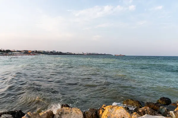 Karadeniz kıyı şeridinin manzarası yumuşak akşam ışığı altında kayalara, plajlara ve ufka vuran dalgalarla dolu..