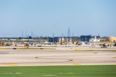 Chicago OHare Havaalanı 'nın arka planında ufuk çizgisi var. Arkasında şehir gökdelenleri olan Chicago, Illinois 'deki OHare Uluslararası Havalimanı' nın editörel manzarası. 