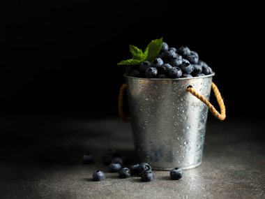 Koyu arkaplanda metal kovada naneli taze yabanmersini.