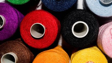 Renkli ipliklerin makaralarının yakın plan çekimi.