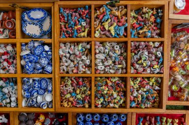 Phuket 'in eski Tayland kasabasındaki yol kenarındaki hediyelik eşya pazarında sergilenen minyatür seramik eşyalar.