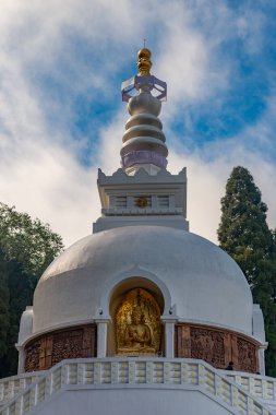 Huzurlu bir Altın Buda heykeli Darjeeling, Batı Bengal, Hindistan 'daki Barış Pagoda' sında. Nipponzan Myohoji Barış Pagoda olarak da bilinen bu kutsal Japon budist stupası barışı, meditasyonu ve ruhani uyumu sembolize eder. Altın heykel yansıyor 
