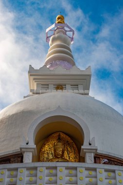 Huzurlu bir Altın Buda heykeli Darjeeling, Batı Bengal, Hindistan 'daki Barış Pagoda' sında. Nipponzan Myohoji Barış Pagoda olarak da bilinen bu kutsal Japon budist stupası barışı, meditasyonu ve ruhani uyumu sembolize eder. Altın heykel yansıyor 