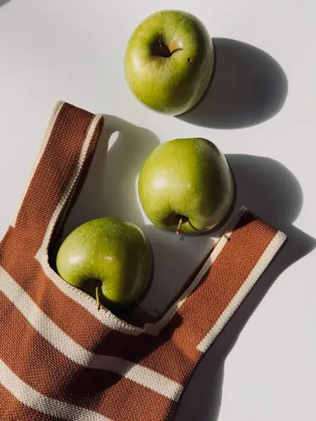 Gri arka planda pipetle beyaz kasede taze elma, sağlıklı bir yaşam tarzı..