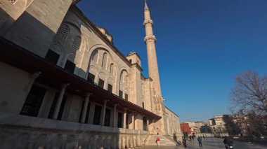İstanbul, Türkiye 'de Minareli Tarihi Osmanlı Camii, Mavi Gök Altında Dini Mimariye Geniş Açı Bakış ve Güneşli Şehir Sahnesinde Turistlerin Yürüyüşü