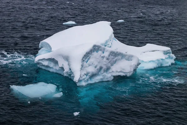 Iceberg floating near the Antactic Peninsula. Blue ice; lower part of the iceberg can be seen below water.