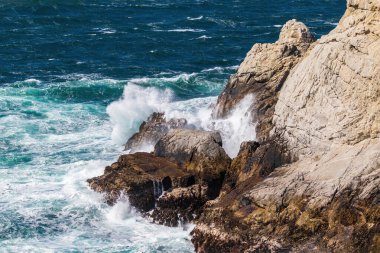 Okyanus dalgası yüksek kayalıklara çarpıyor. Point Lobos Doğa Koruma Alanı, Monterey. Havaya fırlatılan sprey. 