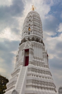 Beyaz, Wat Rakhang, Bangkok, Tayland 'da zonkladı. Kahverengi ve altın heykellerle süslenmiş. Arka planda bulutlu mavi gökyüzü. 