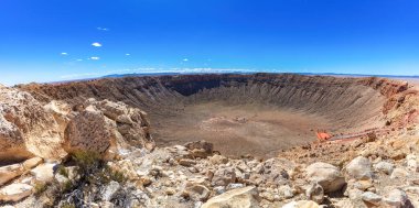 Barringer Meteor crater near Winslow, Arizona; observation platform visible, showing the immense scale. Weathered rocks, desert plants in the foreground. Clear blue sky in above.  clipart