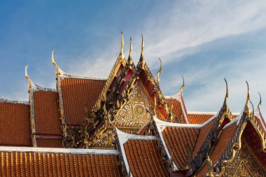 Decorative rooftop in red tile and golden trim, at the Marble Temple (Wat Benchamabophit Dusitvanaram), Bangkok, Thailand. clipart