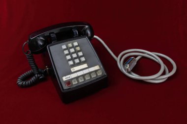 Touchtone multi-line desk telephone, circa 1970. Black bakelite. Red background.  clipart