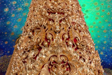 Golden column with intricately designed artwork next to the Emerald green glass pagoda at Wat Paknam Phasi Charoen in Bangkok, Thailand. Beautiful decorated ceiling in the background.  clipart