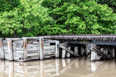 Demiryolu rayları için ahşap köprü, Cloud County, Kansas 'ta bir dereyi kaplayan su üzerindeki yapının yansıması. Arkaplanda yeşil ağaçlar. 